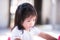 Girl is touchy. Child bowed his head, showing an upset. Children wear white shirts.