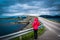 Girl tourist on the background of Storseisundet Bridge Storseisundbrua. Atlantic Ocean Road. Norway