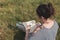 Girl tourist examines through a magnifying glass something on a map with a pen in his hand