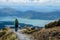 Girl tourist hiker looking at view of lake Rotoaira and lake Taupo from Tongariro Alpine Crossing hike with clouds above