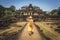 Girl tourist looking at the ancient temple Baphuon.