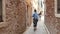 Girl tourist is on a narrow ancient street in Venice, Italy. Traveler walks in Venice.