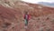 Girl tourist in sunglasses goes on an unusual terrain. red mountains and red earth as on Mars.