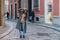 Girl tourist walks along an old street with a cobblestone