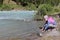 Girl tourist washing hands in a mountain river