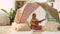 Girl with toy guitar playing in kids tent at home