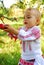 Girl in traditional costume reaching an apple