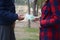 Girl transfers euro bills to the hands of a young guy in forest. Concept of robbery or illegal deal transaction