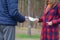 Girl transfers euro bills to the hands of a young guy in forest. Concept of robbery or illegal deal transaction