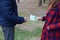 Girl transfers euro bills to the hands of a young guy in forest. Concept of robbery or illegal deal transaction