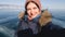 Girl traveler makes a selfie on the winter lake Baikal. The lake in the ice. The sun is bright, the girl wrinkles her nose