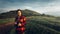 Girl Traveler In Red Plaid Shirt With Binoculars In Hands Looks Into Distance On Landscape Background. Scout Travel Adventure Conc