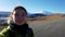 Girl traveler takes a selfie on the road to mount Elbrus. Bright trip to Russia. Autumn landscape. The traveler poses