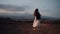 The girl travels with a backpack in a dress against the backdrop of the night city and mountains. Girl alone walks in the