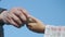 The girl treats the Warrior of the Turkish army with a piece of bread. Close-up of two hands with bread against a blue