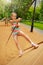 Girl tries to climb on wooden construction