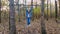 Girl tries to pull up, swings and jumps down off the horizontal bar in the woods