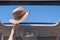 Girl trowing away her straw hat out from open hatch of a vehicle.