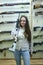 A girl trying the rifle in a gun shop, rifles on a stand