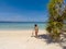 Girl on turquoise water and white beach in Camiaran island in Balabac in Philippines