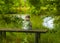 A girl of two years old sitting alone on the bench and looking on the lake