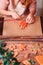 Girl tying Christmas gingerbread cookies with ribbon