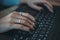 Girl is typing text on the keyboard. close-up of hand keys