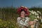 A girl in Ukrainian embroidery with a wreath on her head by the lake in a meadow among the flowers