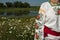 A girl in Ukrainian embroidery with a wreath on her head by the lake in a meadow among the flowers