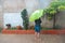 Girl with umbrella standing in the park in the middle of the water Woman alone in the rain