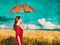 Girl with umbrella on wheat field
