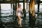 Girl under pier on beach