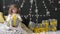 Girl unfolds a Christmas gift against the background of a garland