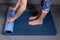 Girl unfolds a mat for yoga or fitness, hands and feet close-up