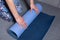 Girl unfolds a mat for yoga or fitness, hands and a mat close-up, concept