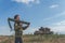 Girl in uniform with a Bazooka on the background of a broken tank