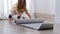 Girl unrolling yoga mat at home