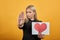 Girl upset unhappy woman holding piece of paper with red heart palm hand stops