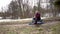 Girl Uran sitting on the ground around early spring, snow