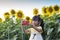 Girl used mobile phone taking a selfie while going travel to sunflower field.