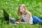 Girl using laptop on grass