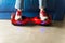 Girl using a red self-balancing two-wheeled board. The gyroscope based dual wheel electric s