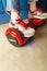 Girl using a red self-balancing two-wheeled board. The gyroscope based dual wheel electric s