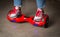 Girl using a red self-balancing two-wheeled board. The gyroscope based dual wheel electric s