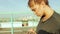 Girl using a smartphone writes sms, standing against the backdrop of the city landscape. A young girl communicates on