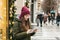 The girl is using a tablet on a city street during the Christmas holidays