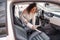 Girl vacuuming car seat with vacuum cleaner in car