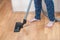 Girl vacuuming in room with vacuum cleaner at home. close up of woman legs with pedicure in home pants. housework concept