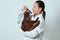 Girl veterinarian holding a Scottish fold cat and looks through the lens at his muzzle