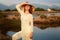 girl in Vietnamese hat against lakes rocks reflection